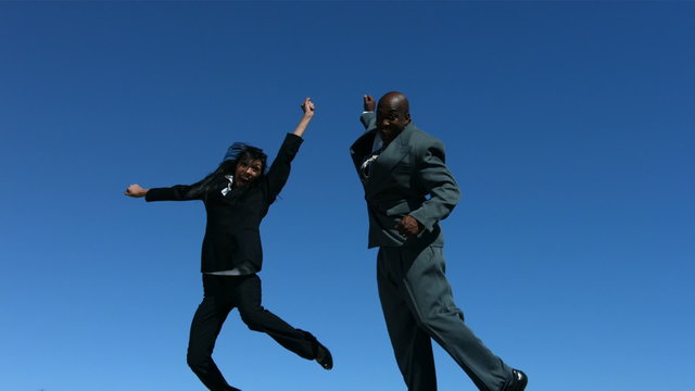 Businesspeople jumping in air celebrating, slow motion