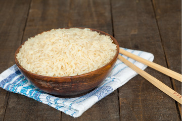 Brown uncooked rice in wooden bowl