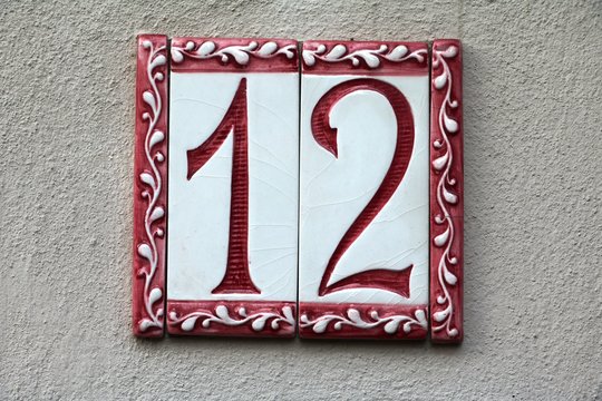 house number twelve at a beige wall
