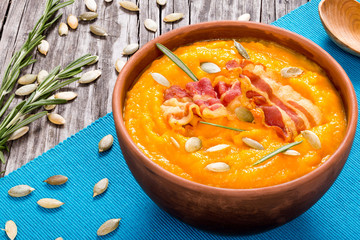 Pumpkin soup with bacon, pumpkin seeds  and  rozemary in the bow