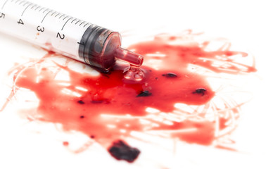 syringe and red blood on white background