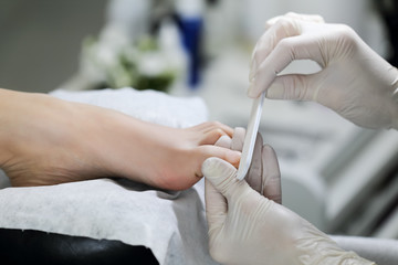 Obraz na płótnie Canvas Professional gash toenails in salon. Close-up master pedicure working tools.