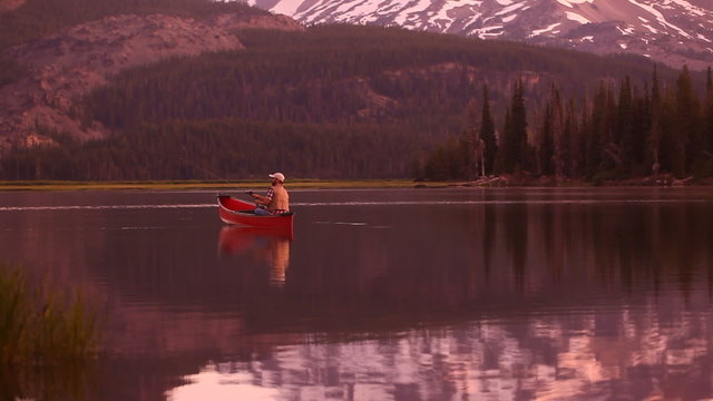 Man in canoe fishing at dusk