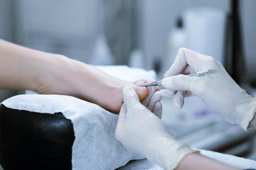 Pedicure process in the bright salon. How to remove the cuticles