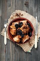 Baked or fried meat , pork ribs with prunes , spices and pepper on a dark wooden background