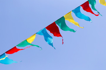 multicolored flags against the blue sky