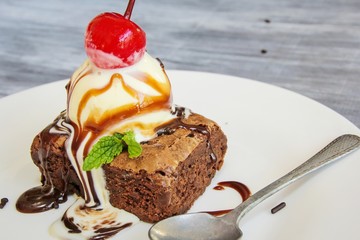 Ice cream and browny with cherry and mint