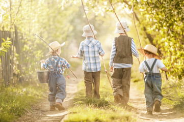 Boy go fishing with fishing rods on a rural street