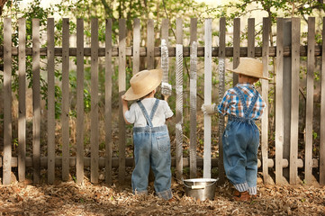 Boys paint old fence