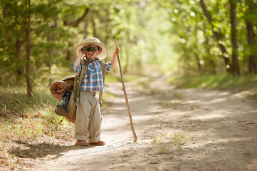 Boy on a forest road with backpacks