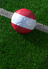 Fototapeta na wymiar Soccer ball and national flag of Austria, green grass