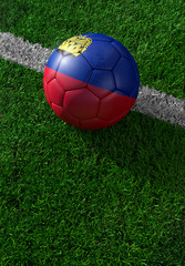 Fototapeta na wymiar Soccer ball and national flag of Lichtenstein, green grass