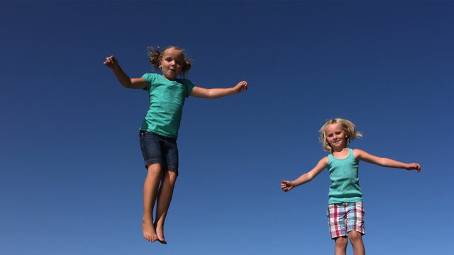 Young girls jumping on trampoline, slow motion