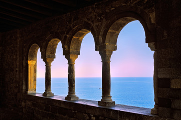 Fototapeta na wymiar arcade windows with columns and view of the sea at sunset