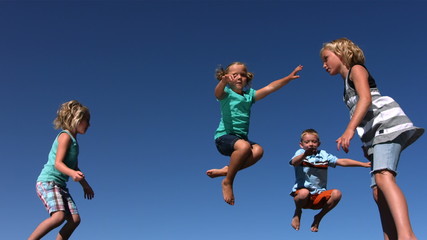Kids jumping on trampoline, slow motion - Powered by Adobe