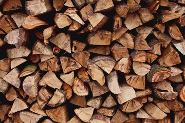 Background of dry chopped firewood logs in a pile