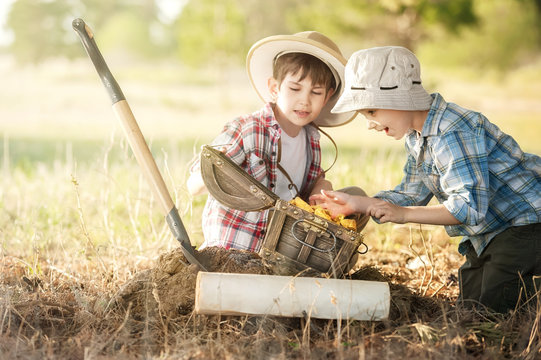 Children treasure hunters under a tree with a trunk