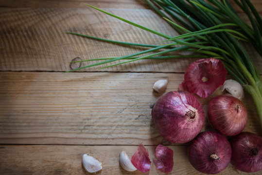 Red onions on wooden table background