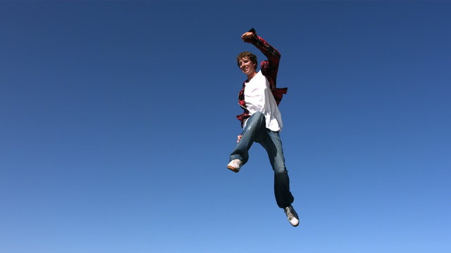 Teen boy jumping into sky, slow motion