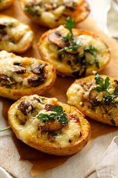 Baked potatoes stuffed with mushroom, onion, herbs and melted cheese