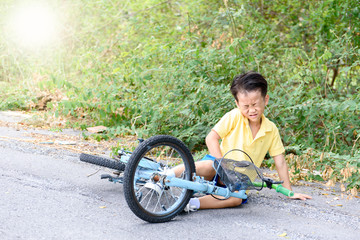 Boy fall from the bicycle during ride on the road