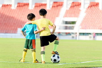 Boy and football in the football grass field