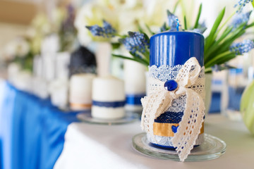 Wedding candles on restaurant table. Wedding decoration in blue colors