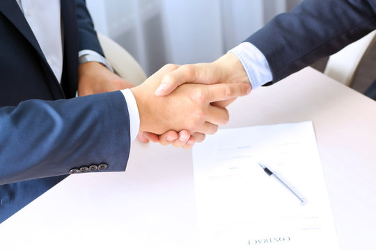Close-up image of a firm handshake between two colleagues after