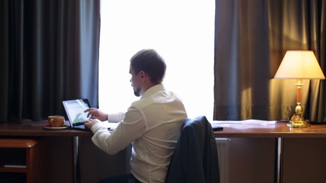 Young manager working on the computer in the hotel room