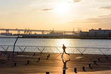 young fitness man runner running at sunrise seaside