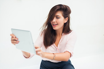 Naklejka premium beautiful young woman in sunglasses sitting in a cafe drinking coffee/tea and work on your tablet on the Internet