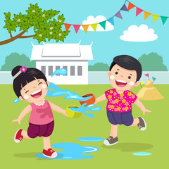 Naklejka premium Thai kids splashing water in Songkran festival at the temple.