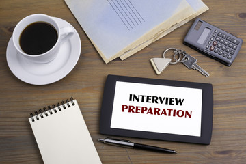 Interview Preparation. Text on tablet device on a wooden table