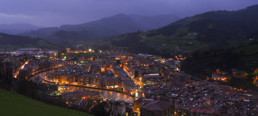 City lights at night with mountains background, Tolosa, Basque Country.