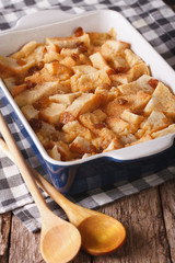 Freshly baked bread pudding with raisins close up in baking dish. Vertical
