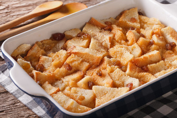 Freshly baked bread pudding with raisins close up in baking dish. horizontal
