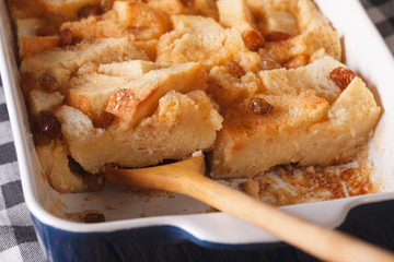 bread pudding with raisins macro in baking dish. horizontal
