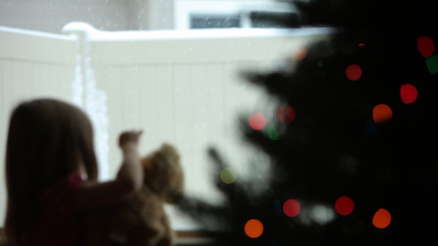 Little gorl watching snow fall