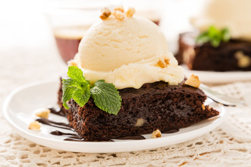 Chocolate brownie with vanilla ice cream, nuts and mint