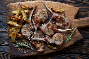 Grilled bobby veal rack steaks on a wooden serving board