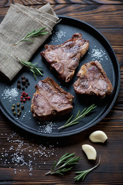 Frying pan with roasted T-bone lamb steaks, studio shot