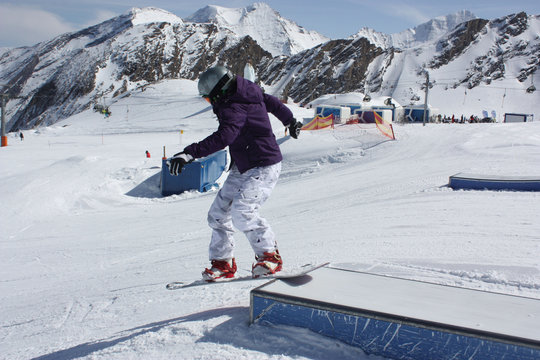 Young snowboarder woman sliding downhill.