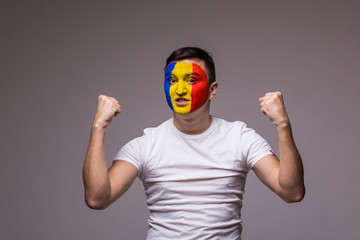 Power and strong emotions of Romanian football fan in game supporting of Romania national team on white background. European football fans concept.