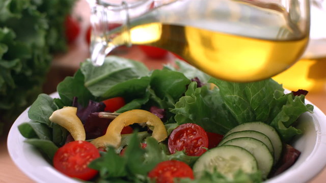 Pouring olive oil onto fresh salad, slow motion