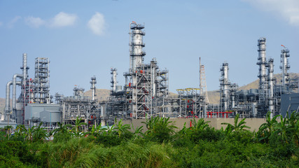 green grass field and Oil refinery factory plant or petrochamica