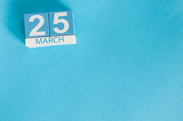 March 25th. Image of march 25 wooden color calendar on blue background.  Spring day, empty space for text.
