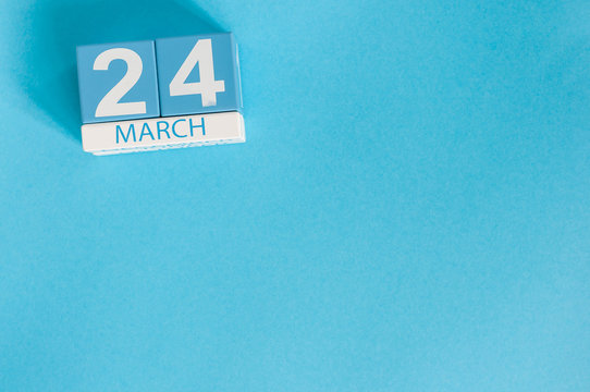 March 24th. Image of march 24 wooden color calendar on blue background.  Spring day, empty space for text