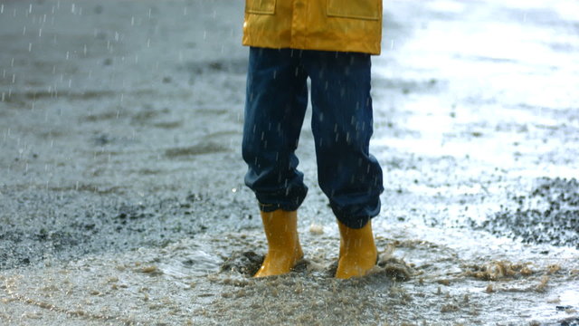 Young boy playing in rain, slow motion