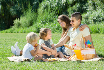 Fototapeta premium Family of four having picnic