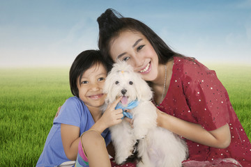 Happy mother and her daughter holding dog
